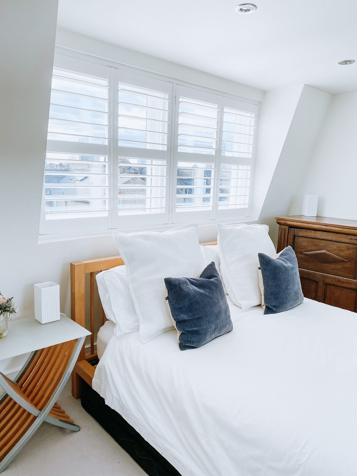 White shutters in a loft bedroom dormer window
