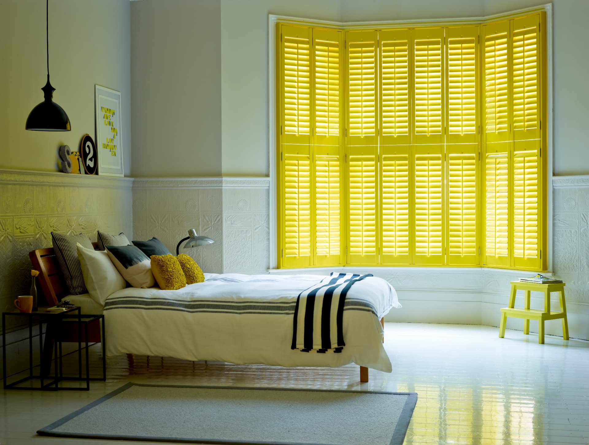 Tier-on-tier shutters in a bay window with the lower tier closed and the upper tier open