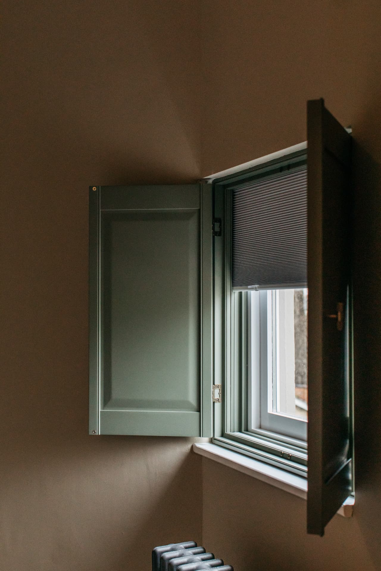 Solid panel shutters with an integrated blackout blind lowered behind them